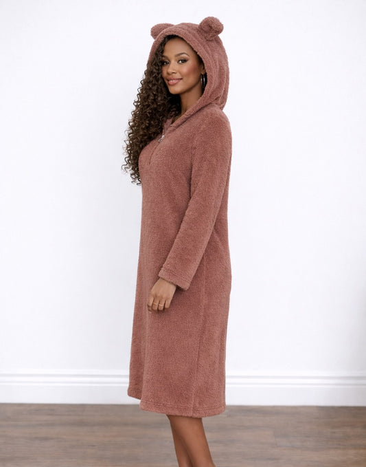 Side view of woman wearing a pink hooded Nightdress with bear ears on a white background.