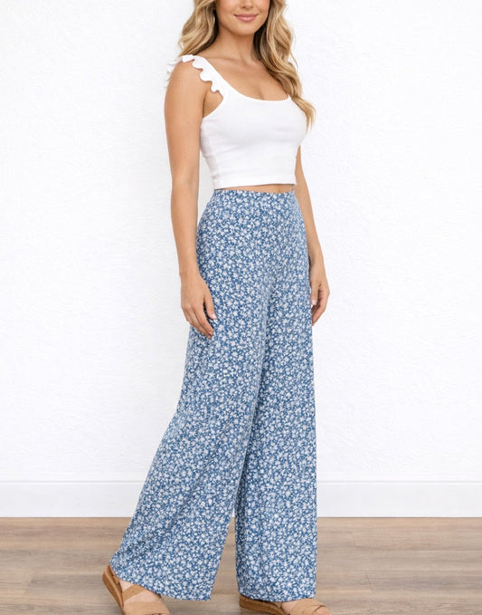 Side view of woman wearing a white top and blue floral High Waist Wide Leg Pants on a white background.