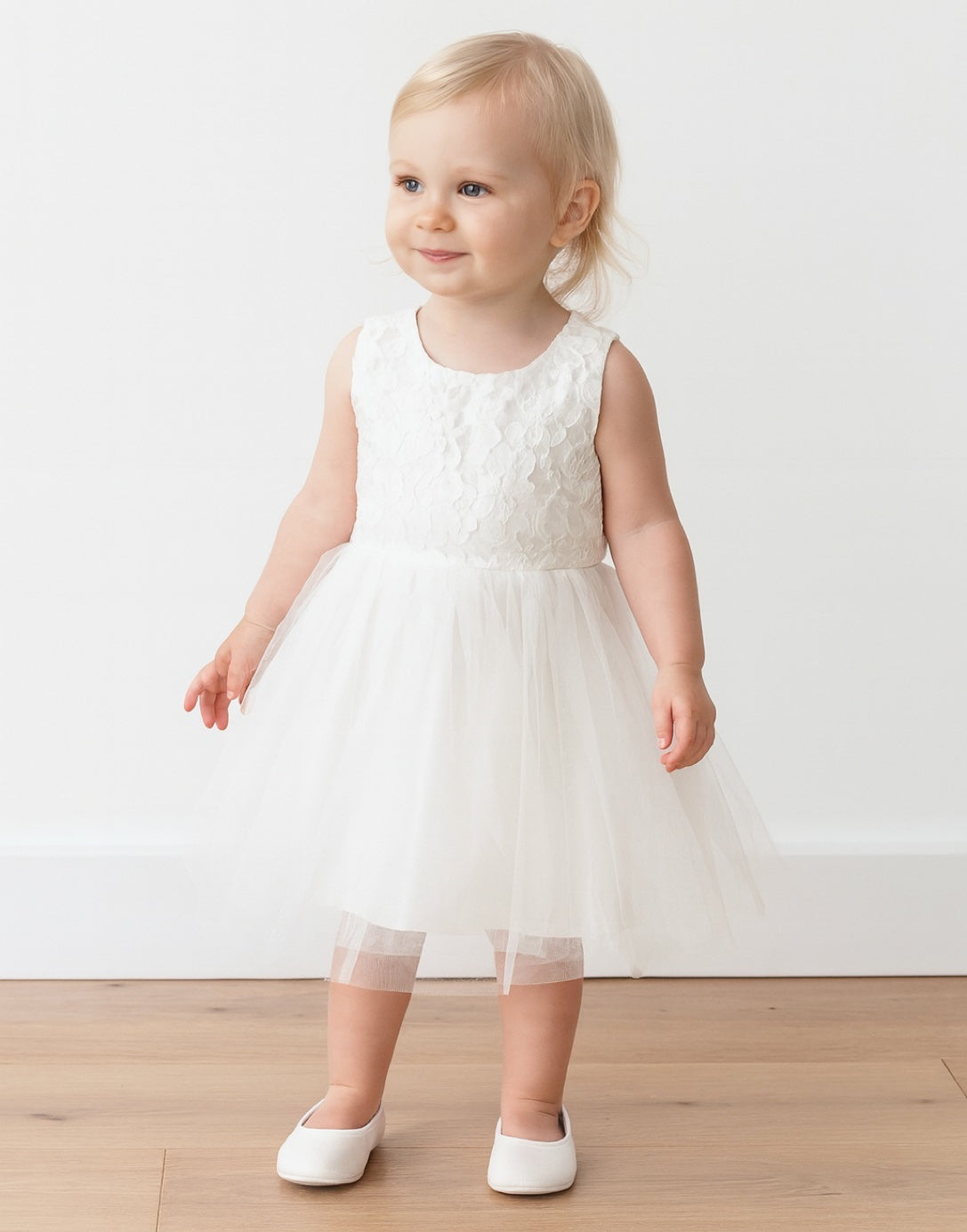 Baby in a white Sleeveless Party Dress with a wooden floor background