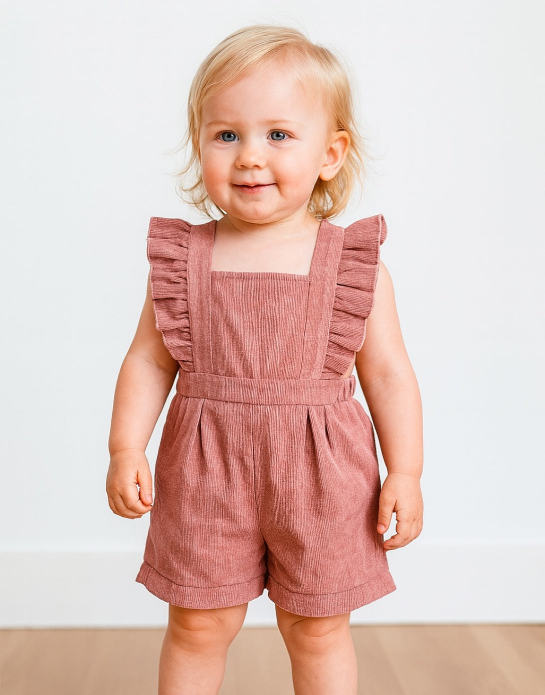 Child wearing a pink Baby Ruffle Sleeve Square Neck Romper against a plain background