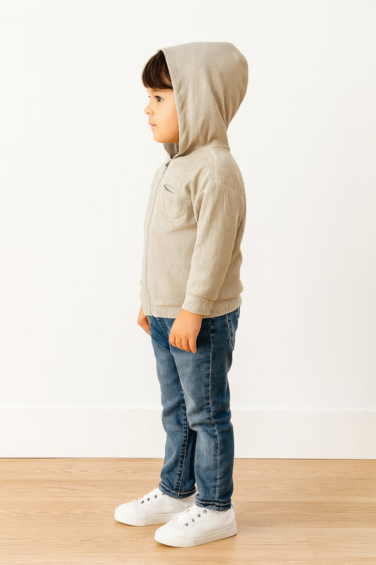 Side view of child wearing a beige Boys Zip Up Hoodie Jacket, blue jeans, and white sneakers on a plain background.