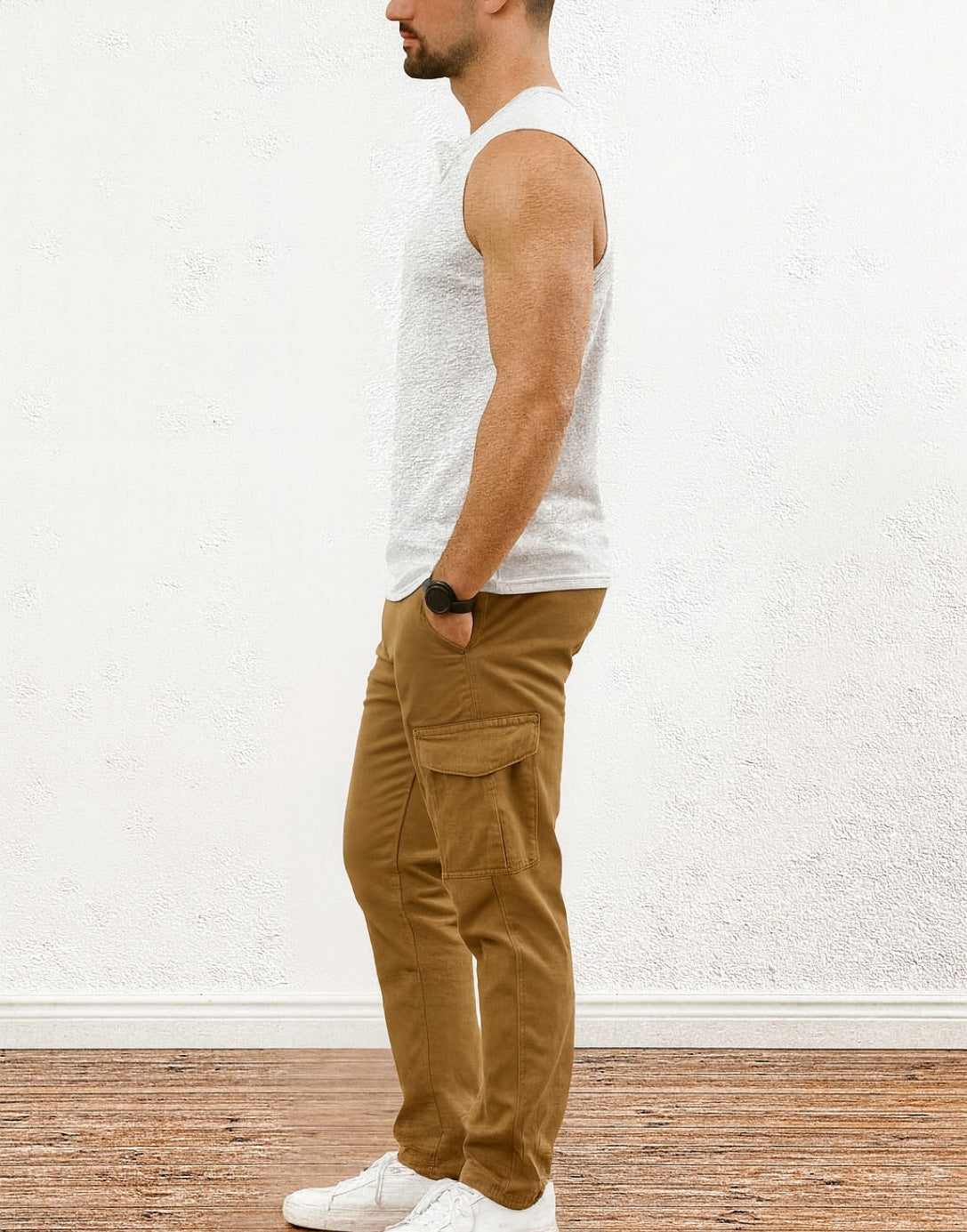 Side view of man wearing a white Button Front Round Neck Tank Top and brown cargo pants against a white wall.