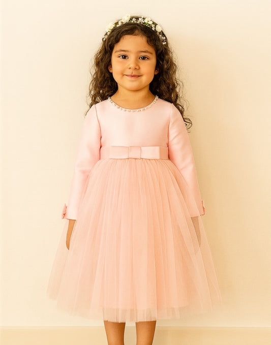Young girl wearing a pink Long Sleeve Princess Tulle Party Dress with a bow on a beige background