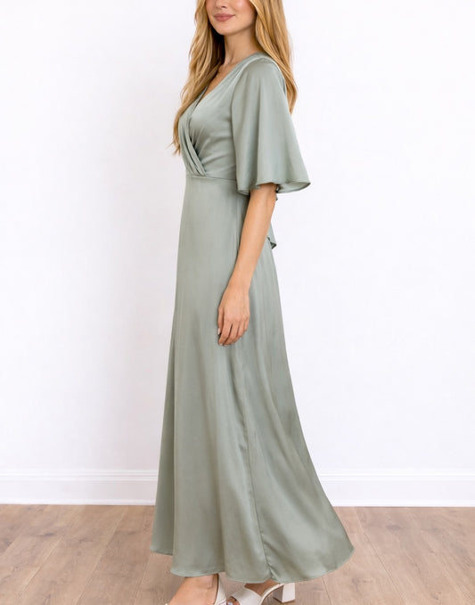 Side view of woman wearing a green Kimono Sleeve Bridesmaid Dress standing against a plain white background.