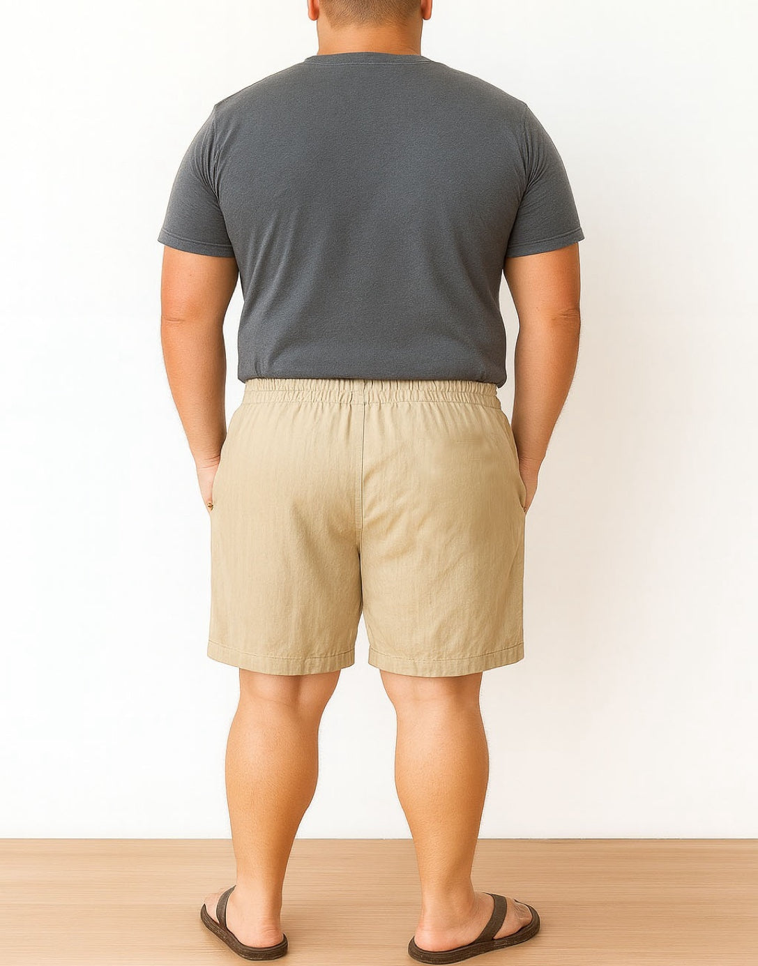 Back view of person wearing a gray t-shirt and beige Plus Size Drawstring Button Front Shorts against a white background.