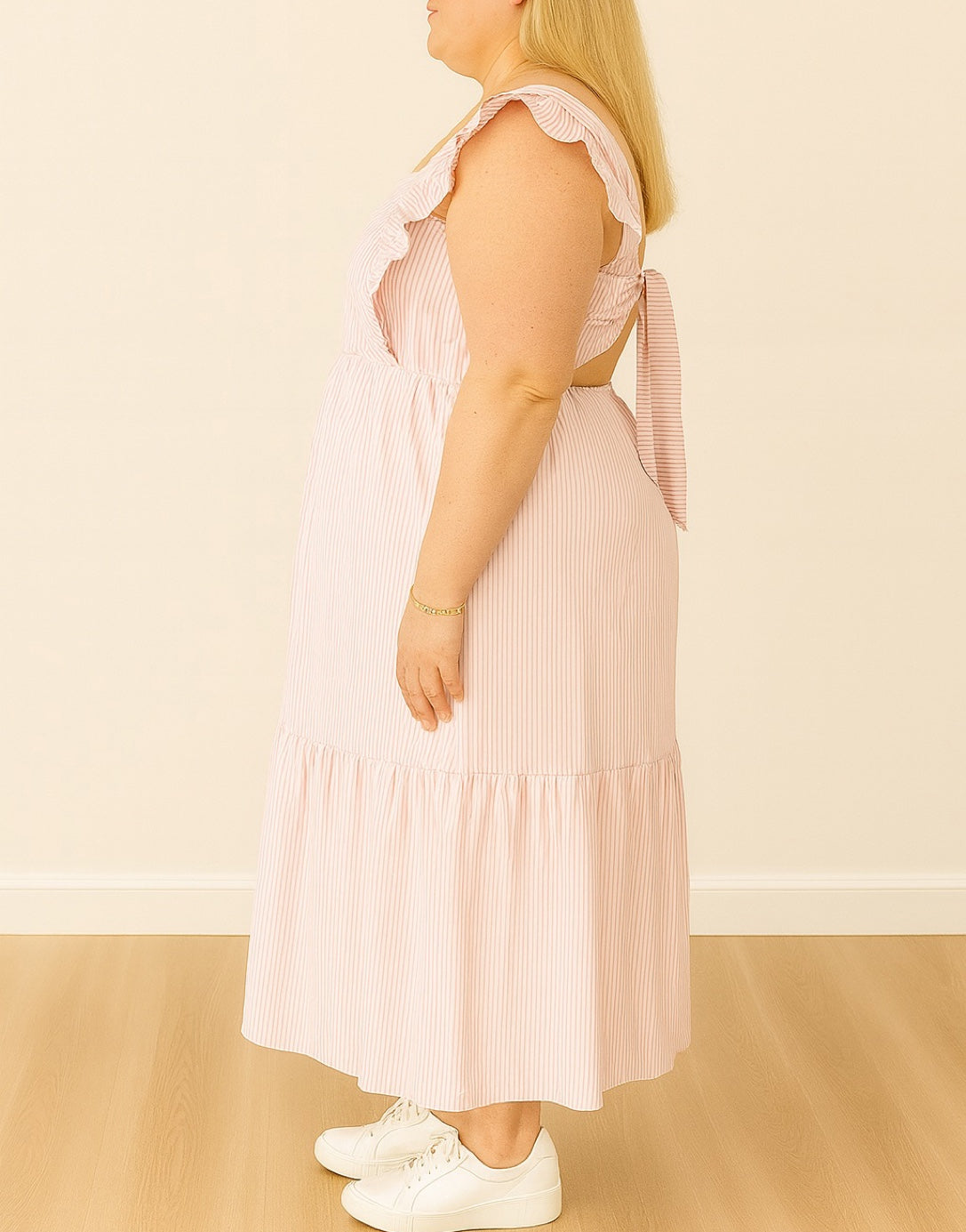 Side view of Woman wearing a pink and white striped Plus Size Square Neck Maxi Dress with ruffled straps on a plain background.