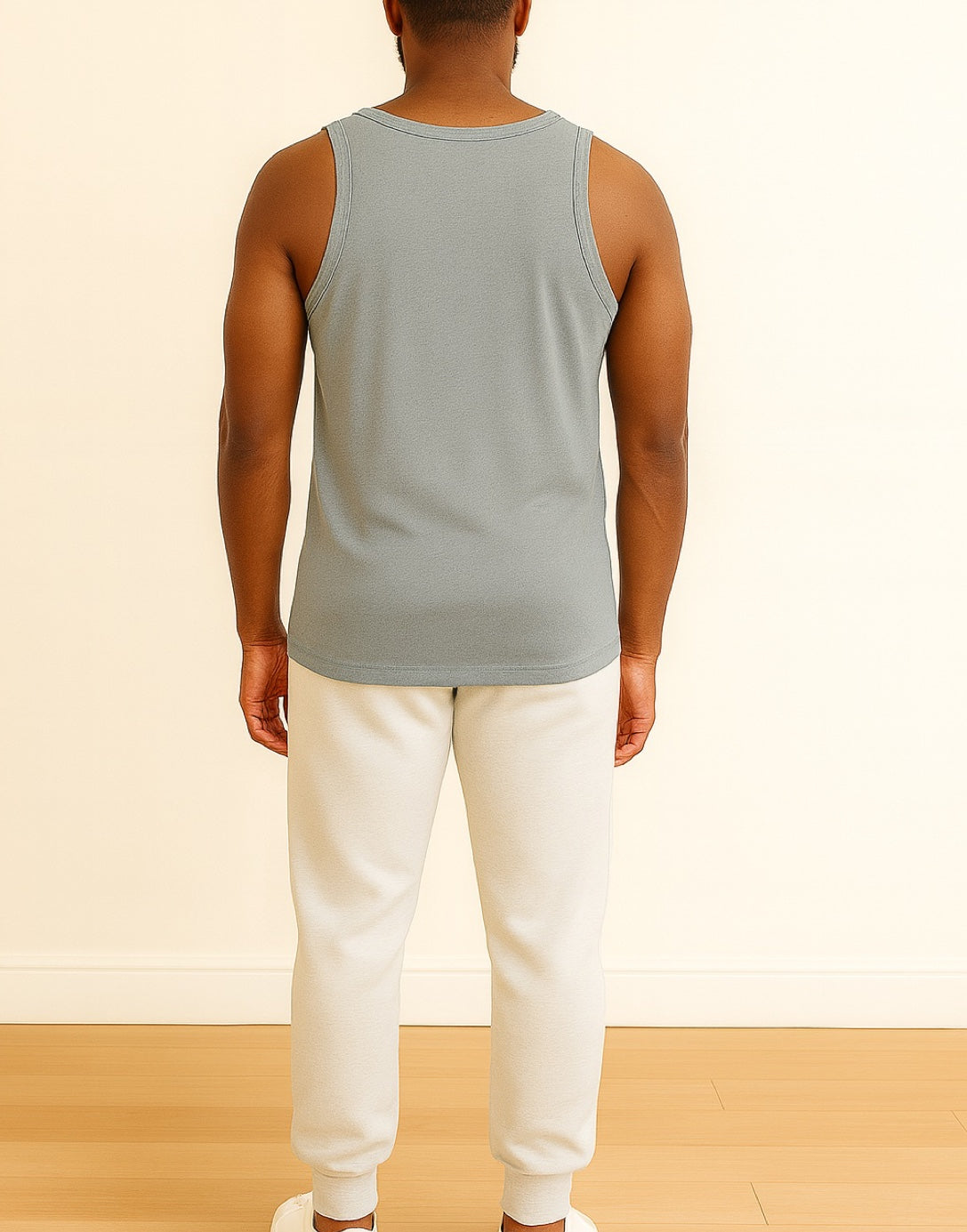 Back view of person wearing a light gray Round Neck Tank Top and white pants on a beige background