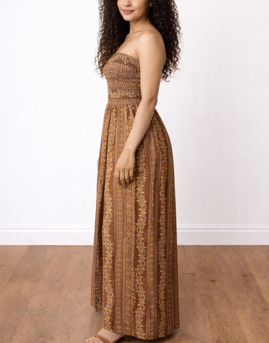 Side view of woman wearing a brown strapless Shirred Tube Jumpsuit on a white background.