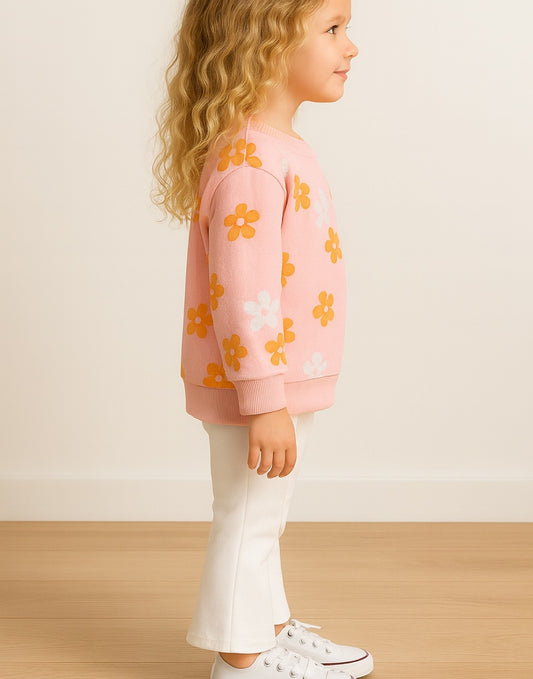 Side view of child wearing a pink floral sweatshirt and white Knit Flare Leg Pants on a plain background.
