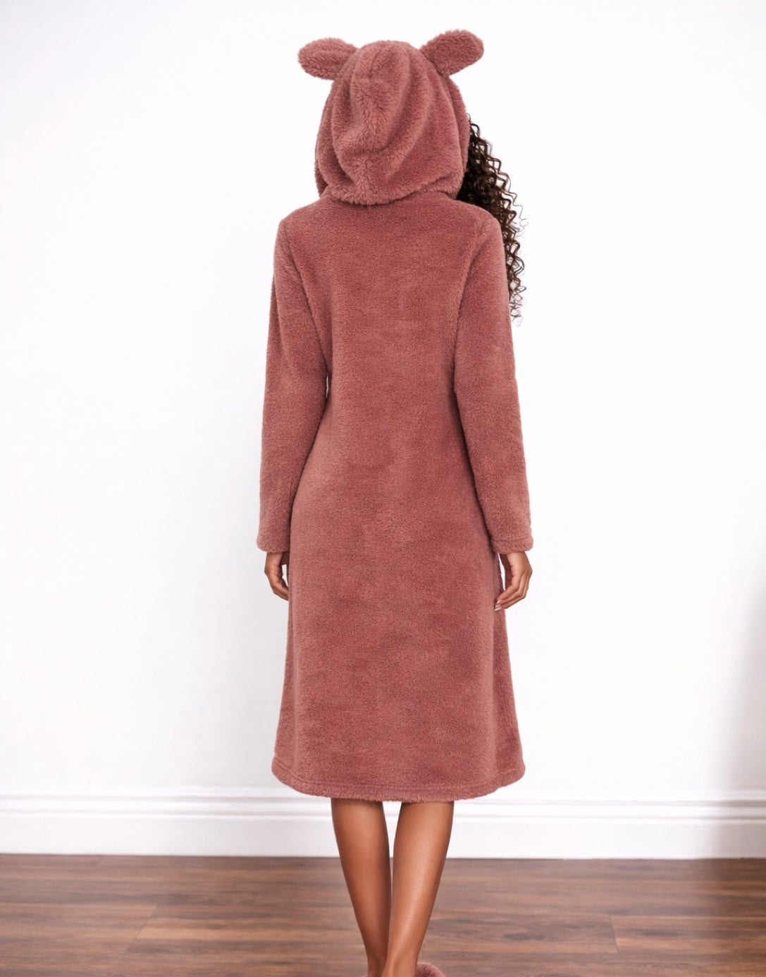 Back view of woman wearing a pink hooded Nightdress with bear ears on a white background.