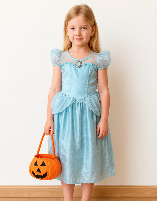 Young girl in a light blue dress holding an orange Halloween Pumpkin Trick Or Treat Bag against a plain background.