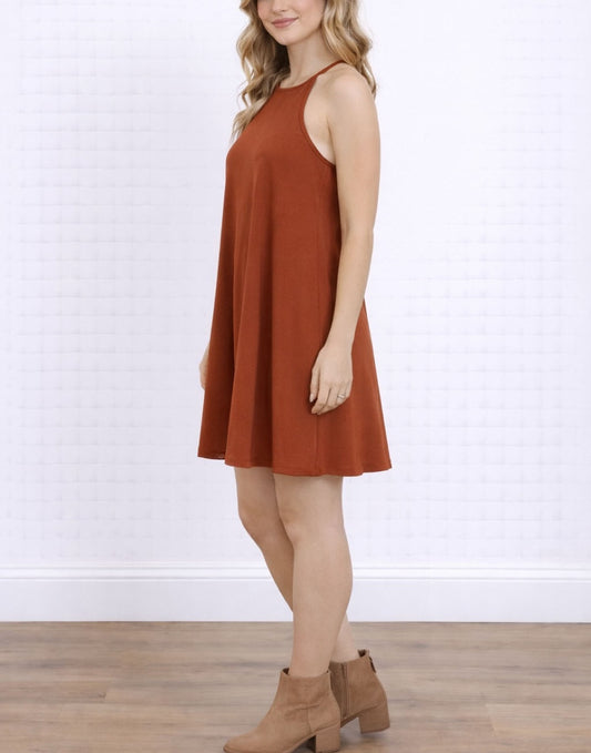 Side view of woman wearing a rust-colored Halter Cami Mini Dress against a white background. 