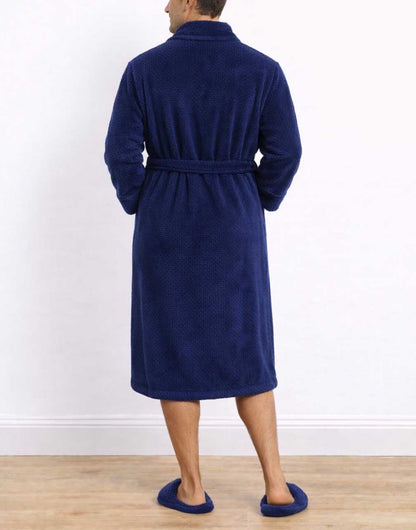 Back view of man wearing a blue Shawl Collar Bathrobe and matching slippers on a white background.
