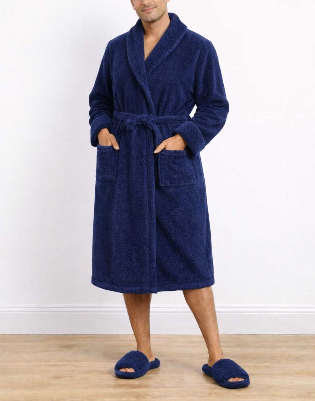 Man wearing a blue Shawl Collar Bathrobe and matching slippers on a white background