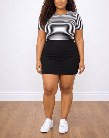 Woman wearing a black and white striped crop top and black Plus Size Bodycon Mini Skirt on a plain background.