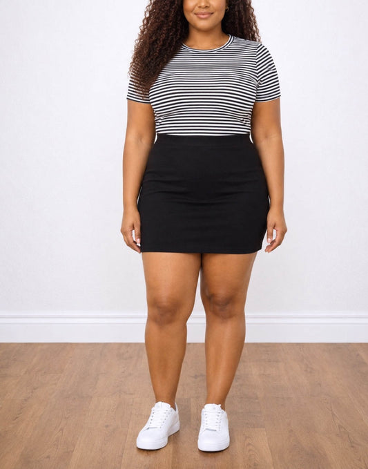 Woman wearing a black and white striped crop top and black Plus Size Bodycon Mini Skirt on a plain background.