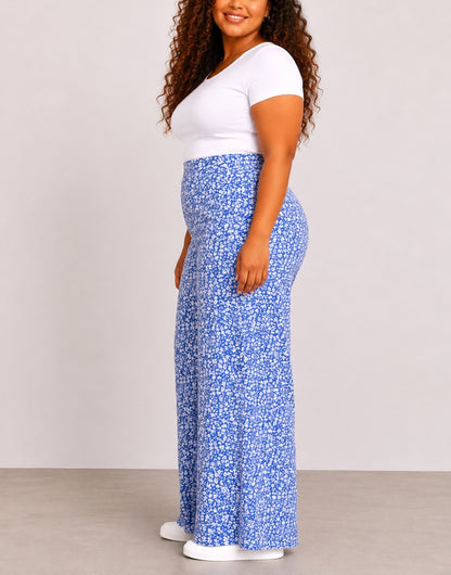 Side view of woman wearing blue floral Plus Size High Waist Wide Leg Pants and a white top against a plain background.