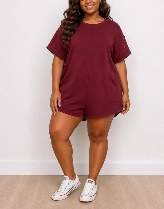 Woman wearing a maroon Plus Size Oversized Tee Romper with white sneakers against a white background
