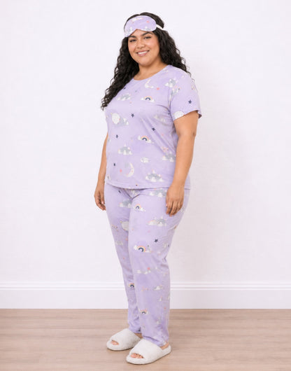 Side view of a woman modeling a light purple Plus Size Pajama Set with a matching sleep mask. The pajamas feature a whimsical print of clouds, stars, and rainbows.