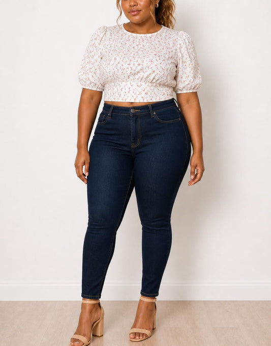 Woman wearing a white floral Plus Size Puff Sleeve Crop Blouse and dark blue jeans against a plain background