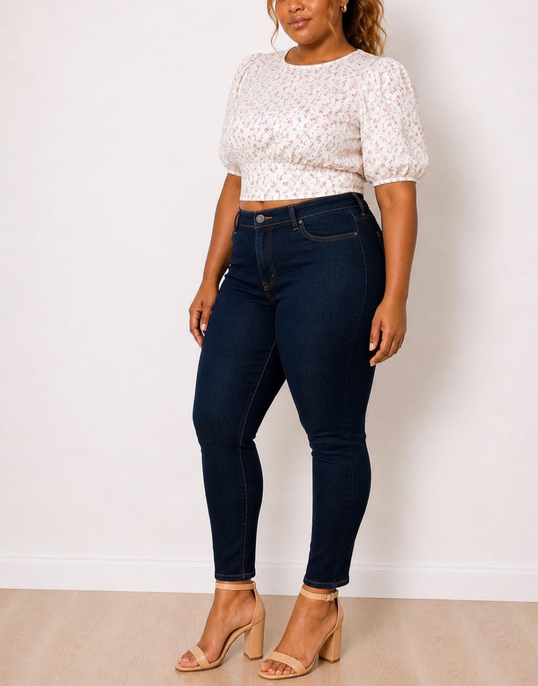 Side view of woman wearing a white floral Plus Size Puff Sleeve Crop Blouse and dark blue jeans against a plain background.