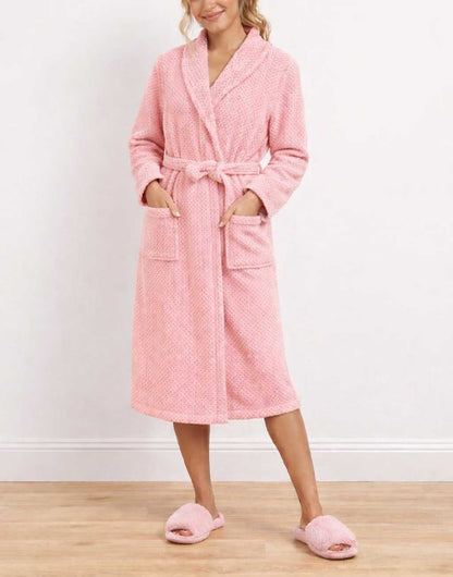 Woman wearing a pink Shawl Collar Bathrobe and matching slippers on a wooden floor.