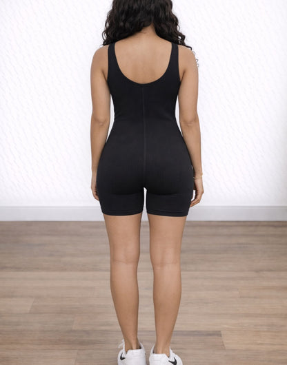Back view of woman wearing a black Unitard Knit Romper on a white background.