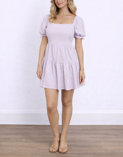 Woman wearing a light purple Puff Sleeve Mini Dress with puff sleeves against a white background