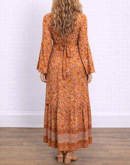 Back view of woman wearing an orange floral Bell Sleeve Tie Front Wrap Maxi Dress against a white background.