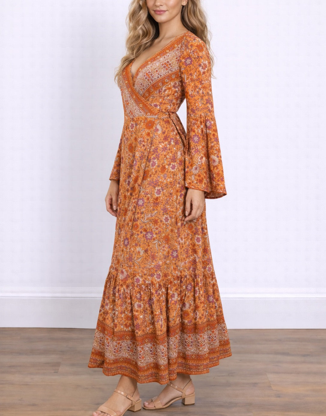Side view of woman wearing an orange floral Bell Sleeve Tie Front Wrap Maxi Dress against a white background.