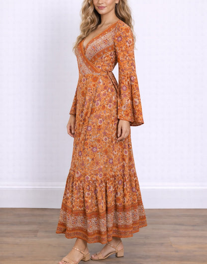 Side view of woman wearing an orange floral Bell Sleeve Tie Front Wrap Maxi Dress against a white background.