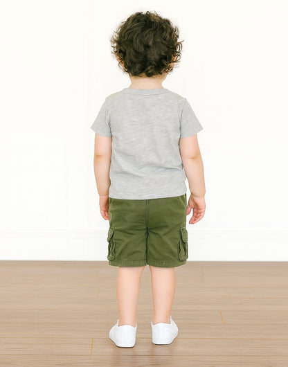 Back view of child wearing a gray T-Shirt and green cargo shorts on a white background