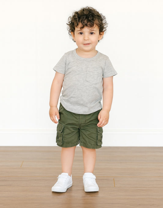 Child wearing a gray Pocket Patched Tee and green cargo shorts on a white background