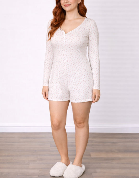 Woman wearing a white Button Front Knit Sleep Romper with a subtle pattern on a plain background