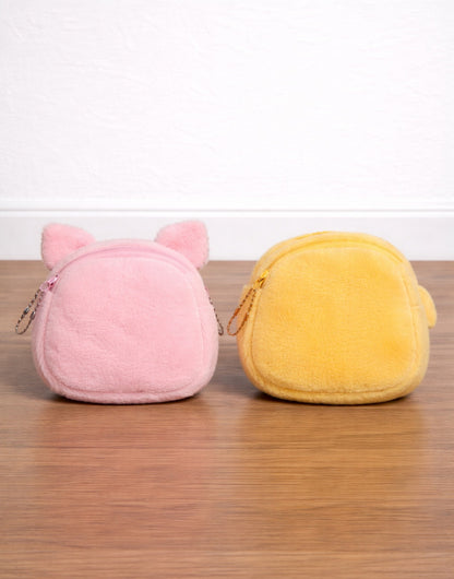 Back view of two plush coin purses, one pink and one yellow, on a wooden surface with a white background.