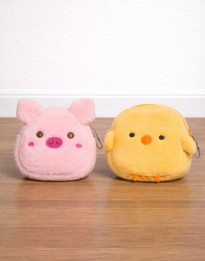 Pink pig and yellow chick plush Coin Purse on a wooden surface with a white background