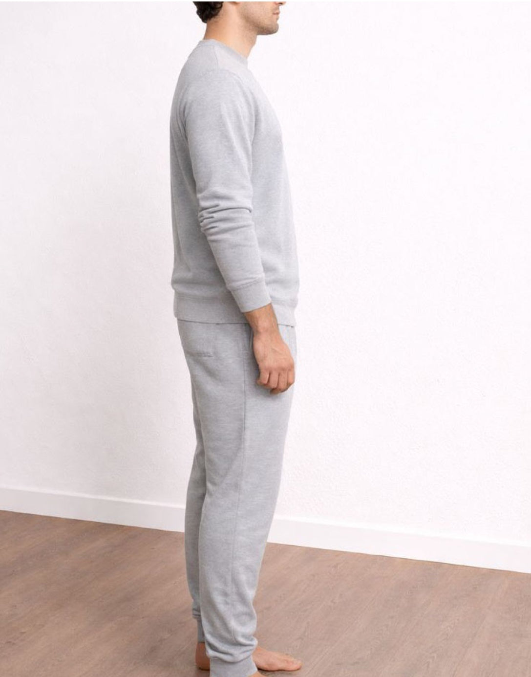 Side view of person wearing a gray sweatshirt and Drawstring Jogger Pants against a white wall.