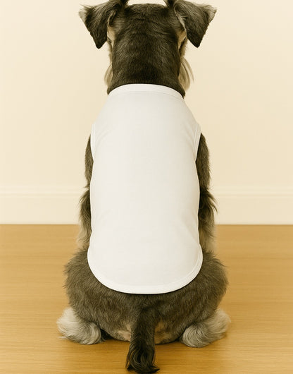 Back view of dog wearing a white knit t-shirt sitting on a wooden floor with a beige wall background