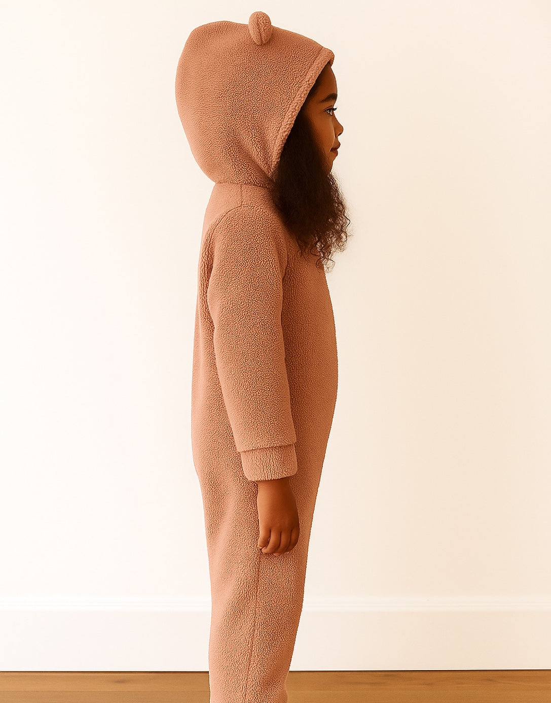 Side view of child wearing a pink 3D Ear Hooded Sleep Jumpsuit with bear ears on a white background.