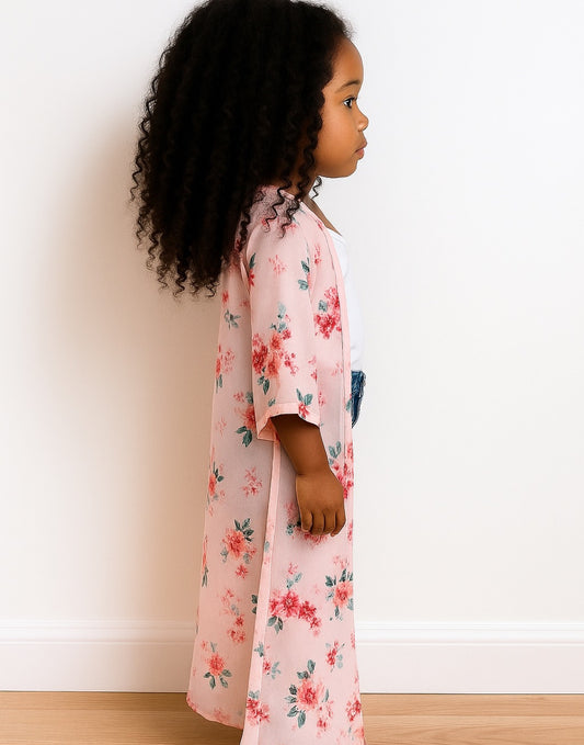 Side view of child wearing a floral Kimono Sleeve Robe standing against a white wall.