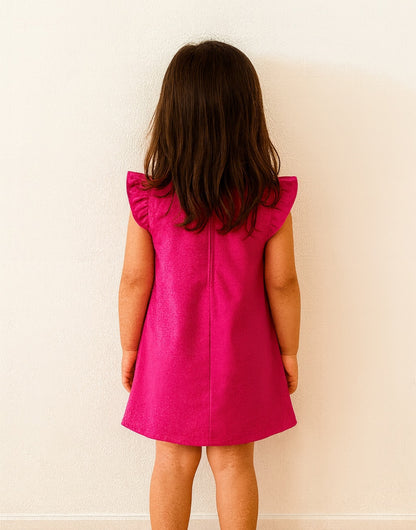 Back view of young girl wearing a pink Ruffle Sleeve A-Line Dress against a plain background