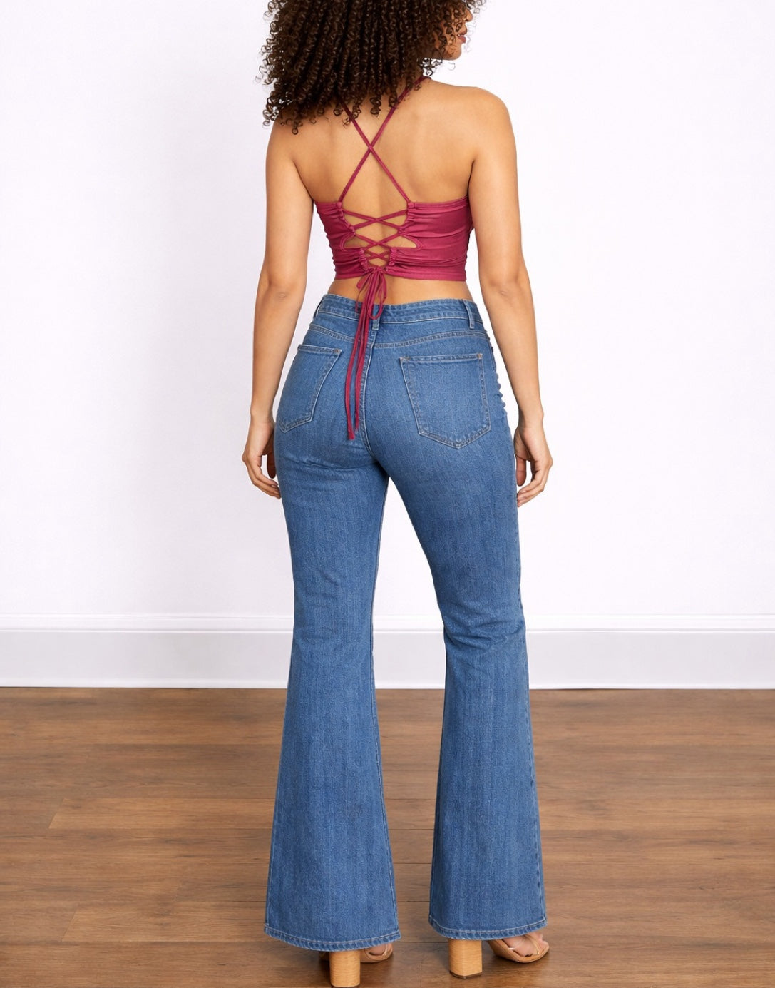 Back view of woman wearing a red bandana Handkerchief Halter Top and blue jeans on a white background.