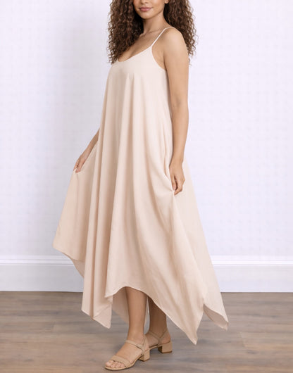 Side of woman wearing a beige Handkerchief Hem Cami Dress against a white background.