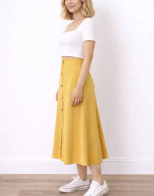 Side view of woman wearing a white top and mustard yellow Button Front Midi Skirt on a white background.