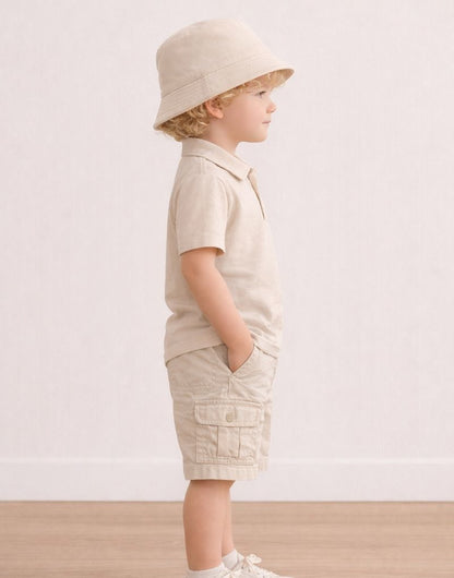 Side view of child wearing a beige outfit with a Bucket Hat on a plain background.