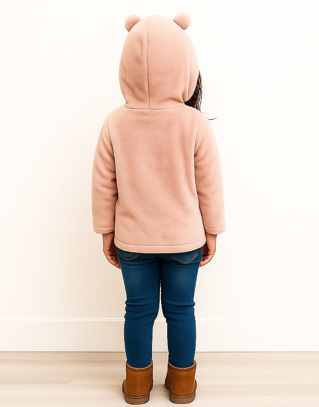 Back view of child wearing a pink Teddy Ear Hooded Jacket with bear ears, blue jeans, and brown boots on a white background.