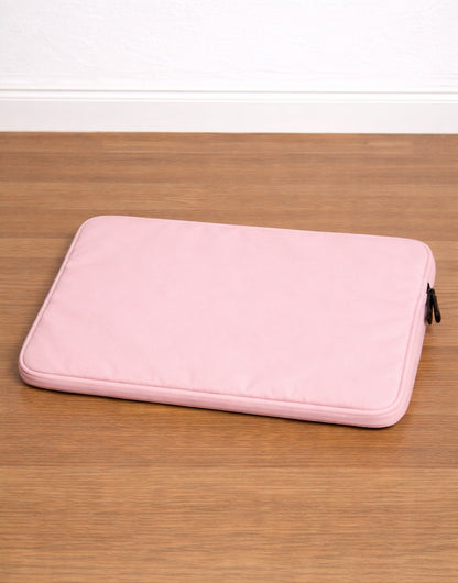 Back view of pink Laptop Bag on a wooden surface with a white background.