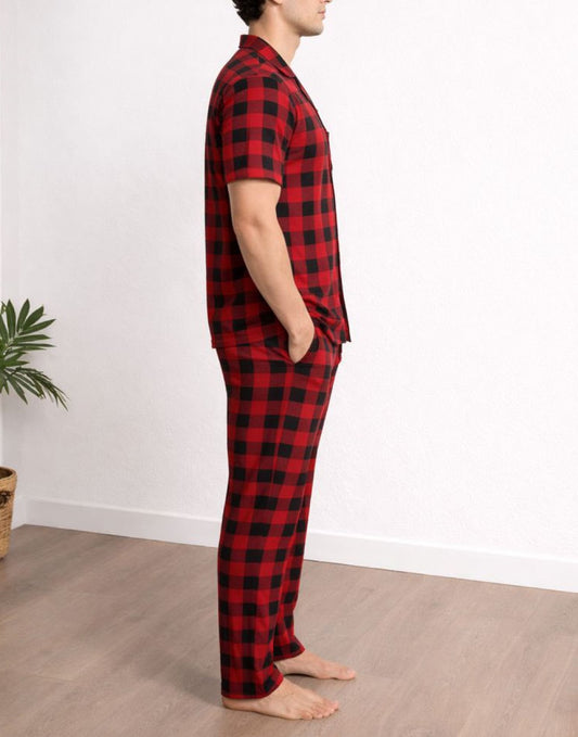 Side view of person wearing red and black plaid pajama shirt and Elastic Waist Pants set standing against a white wall.