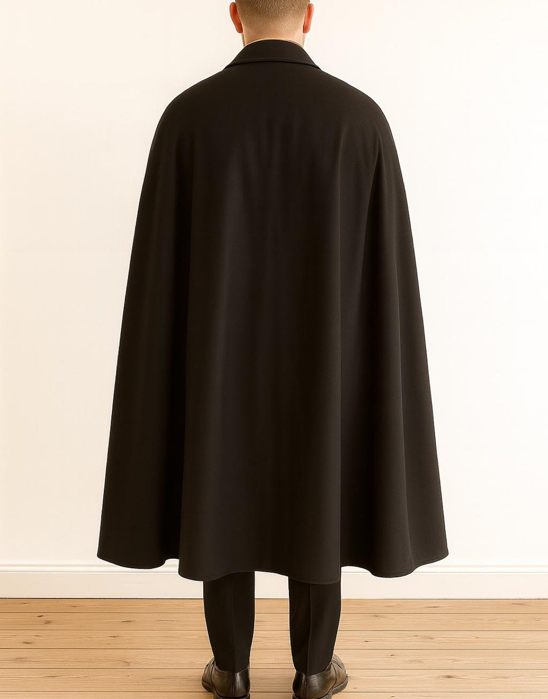 Back view of person wearing a black Vampire Cape standing against a plain wall