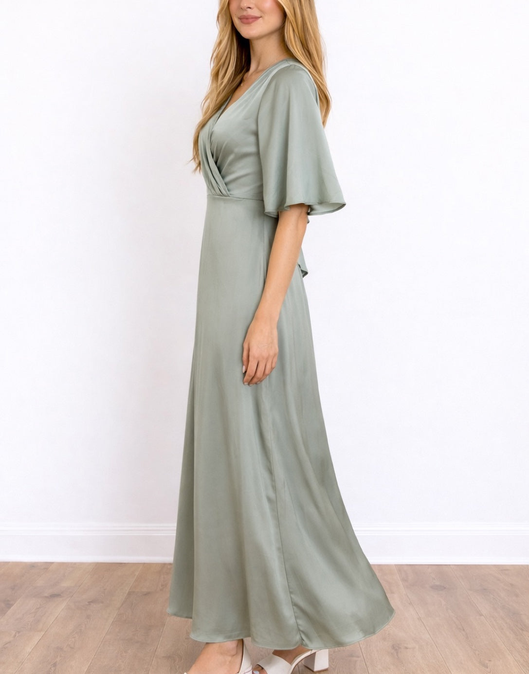 Side view of woman wearing a green Kimono Sleeve Bridesmaid Dress standing against a plain white background.